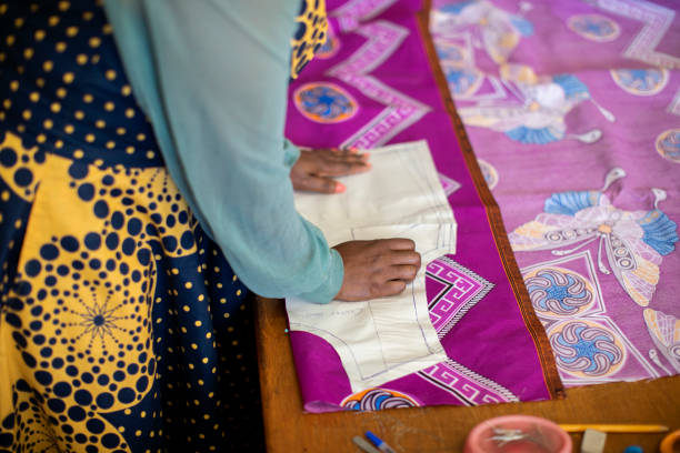 istock An African woman cutting patterns in fabric in her studio. 1257414011