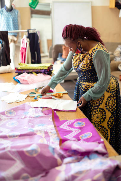 istock An African woman cutting patterns in fabric in her studio. 1257414563