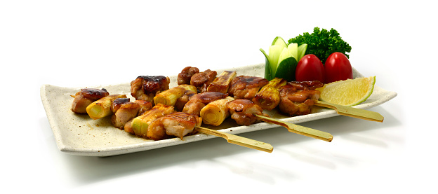 Yakitori Grilled Chicken and leek Bunching onion Skewers Japanese Food fusion style perfect BBQ Goodtasty Easy dish decorate carved Cucumber flower, parsley and tomatoes popular in A sian sideview