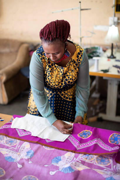 istock An African woman cutting patterns in fabric in her studio. 1257414924