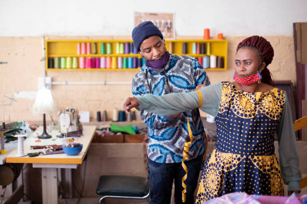 istock An African man taking a woman's measurements. 1257416178