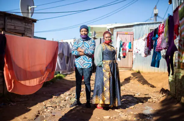 Photo of An African man and woman walking to work in Kayamandi township.