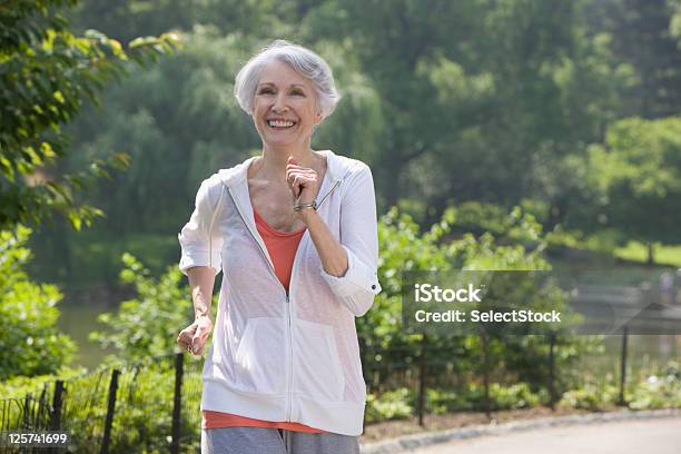 Mujer De Edad Avanzada Para Trotar En El Parque Foto de stock y más banco de imágenes de Andar - Andar, Mujeres mayores, Tercera edad