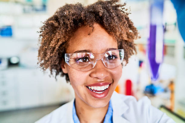 istock Smiling young female scientist analyzing a test tube sample in the light 1257417086