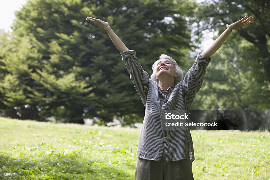 Idosos mulher com os braços abertos no parque - Foto de stock de Olhos Fechados royalty-free