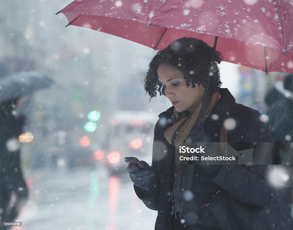 Joven mujer enviando mensajes de texto en la nieve - Foto de stock de Mujeres libre de derechos