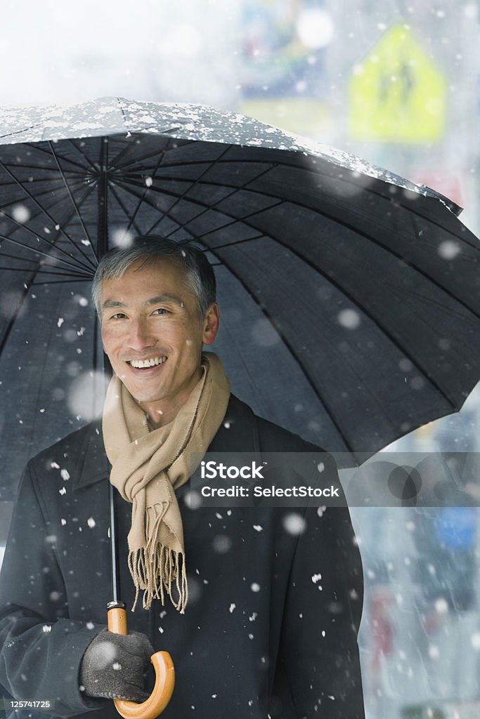 Porträt eines mittleren Alter Mann lächelnd im Schnee - Lizenzfrei Regenschirm Stock-Foto