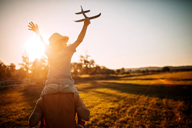 Be free Father caring kid on shoulders in nature toy airplane stock pictures, royalty-free photos & images