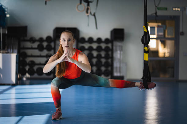 istock Young woman doing sit ups with the TRX. 1257425566