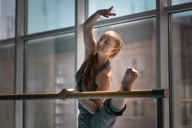 młoda kobieta robi rozciąganie na barre balet. - beautiful ballet dancer adult ballet zdjęcia i obrazy z banku zdjęć