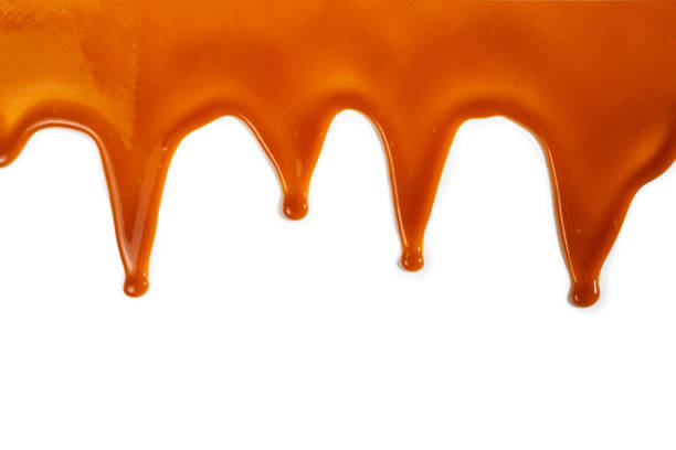 istock Background of flowing caramel sauce isolated on white. 1257425806