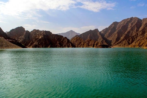 istock Beautiful deep green Hatta lake with rocky Hajar Mountains on background. 1257426817