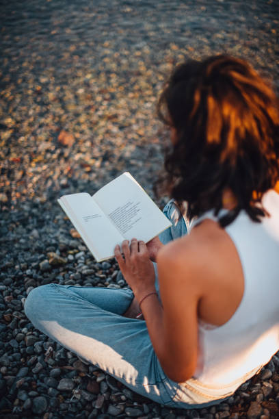 Woman Reading Book and Relaxing at the Beach