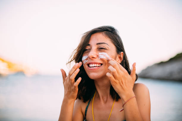 istock Woman Applying Sunscreen on Her Face 1257429317