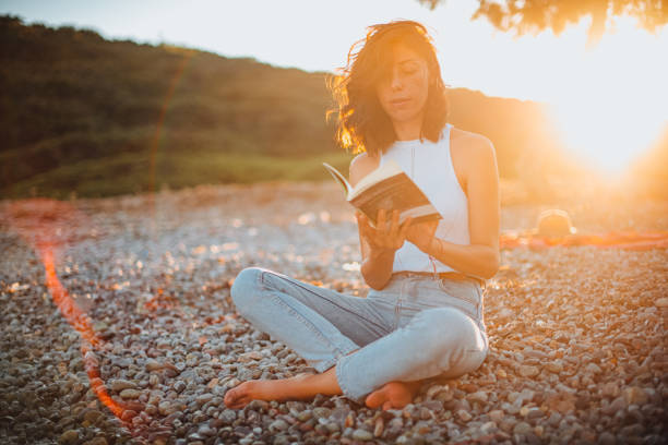 Woman Reading Book and Relaxing at the Beach