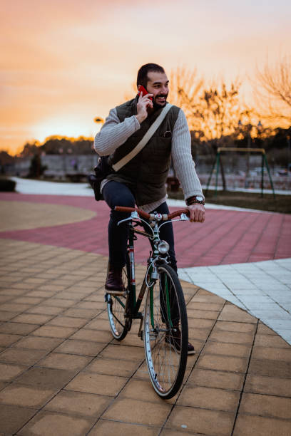 istock Young man with a bicycle using smart phone in the cit park 1257431978