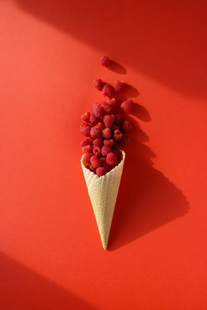 istock Fresh ripe raspberries in a waffle cone on a red background. 1257432006