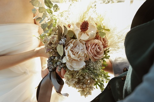 Beautiful bouquet of fresh roses, carnation, freesias, hydrangea, eucalyptus in tender pink and white colors, bouquet of flowers close up.