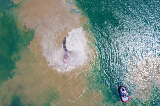 вид с воздуха на буксир пожаротушения в порту. - fire boat стоковые фото и изображения
