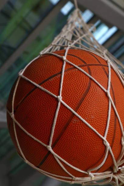 istock One basketball ball hanging in mesh sack 1257432229