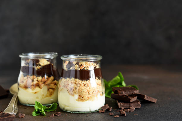 Dessert in a glass. Cheesecake with chocolate in a glass on a dark, concrete background. Dessert in a glass. Cheesecake with chocolate in a glass on a dark, concrete background. tiramisu glass stock pictures, royalty-free photos & images