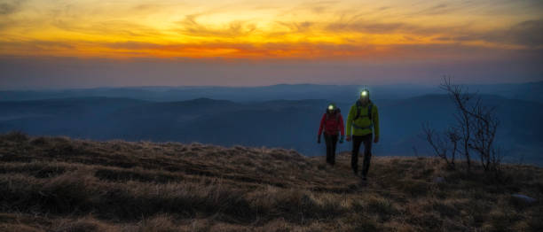 Couple hiking on a meadow at dusk