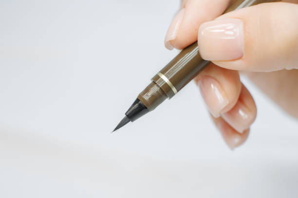 istock Eyebrow correction procedure tools. Pencil for brows and eyes in female hand. Instruments for tweezing eyebrows. Microblading brow. Permanent makeup. 1257438672