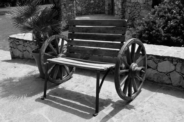 Wagon wheel bench A black & white wooden bench made using two wagon wheels wagon wheel bench stock pictures, royalty-free photos & images