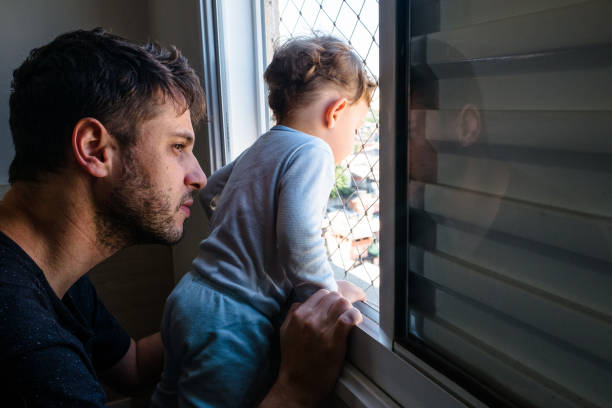 istock Father and Son Looking Through the Window 1257440002
