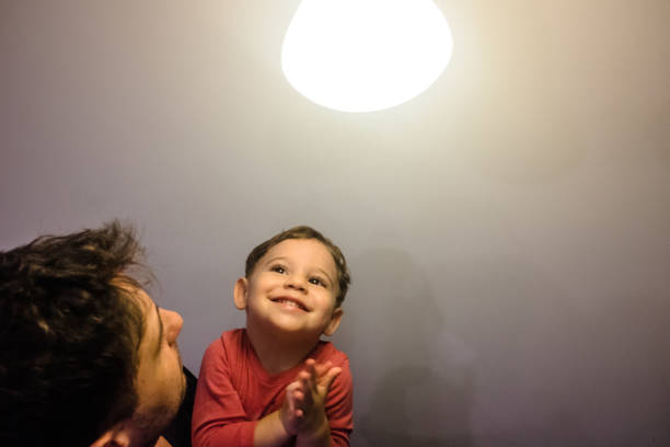 istock Father and Son Playing with a Lamp 1257440197