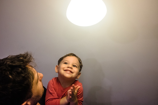 Father and son toddler playing with a lamp