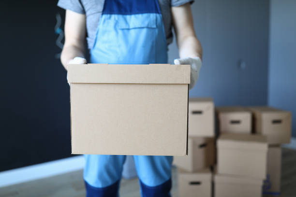istock Man in work clothes is standing in office with box 1257440880