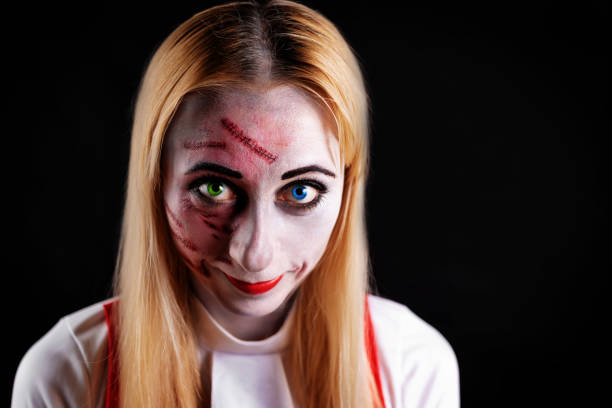 istock blond haired witch with green and blue eyes on a black background for Halloween 1257445117