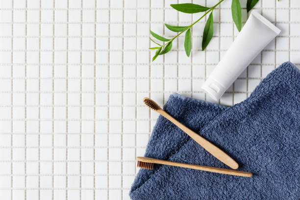 istock Bamboo toothbrush, toothpaste and towel on white mosaic background top view. 1257445769
