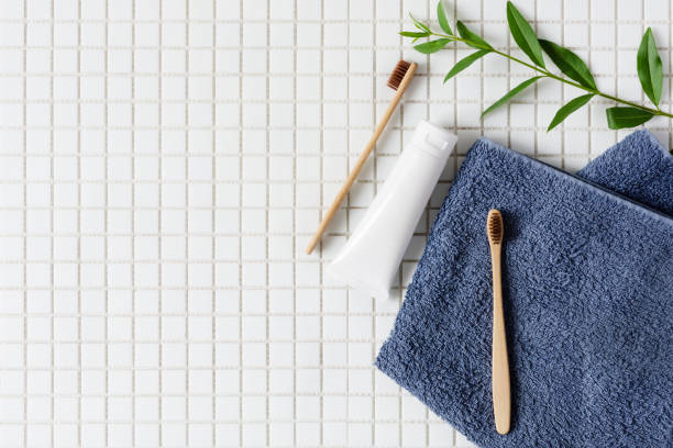 istock Bamboo toothbrush, toothpaste and towel on white mosaic background top view. 1257445776