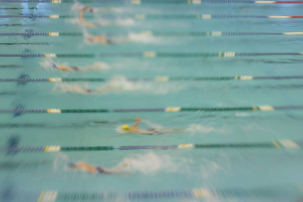 Swimmers Racing in Pool Abstract Motion Blur Swim Swimmers swim freestyle at a competition. Abstract motion blur. swimming pool lane ropes stock pictures, royalty-free photos & images