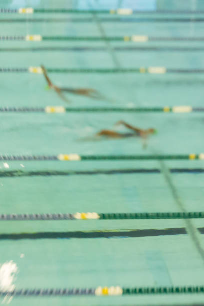 Swimmers Racing in Pool Abstract Motion Blur Swim Swimmers swim backstroke at a meet. Abstract motion blur. swimming pool lane ropes stock pictures, royalty-free photos & images