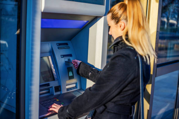 istock Young woman taking money from ATM 1257447143