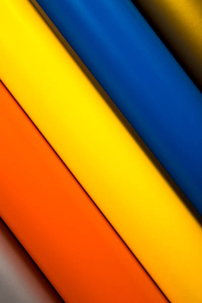A Colorful vinyl rolls on wooden background with your necessary instruments placed in a row of many colors