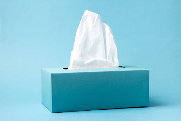 Blue tissue box on a blue background Light blue tissue box on blue background. Cold and flu concept. Minimal monochromatic composition. facial tissue stock pictures, royalty-free photos & images
