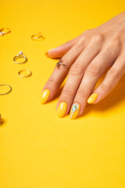 istock Summer yellow manicure with crystals and jewelry ring 1257449975