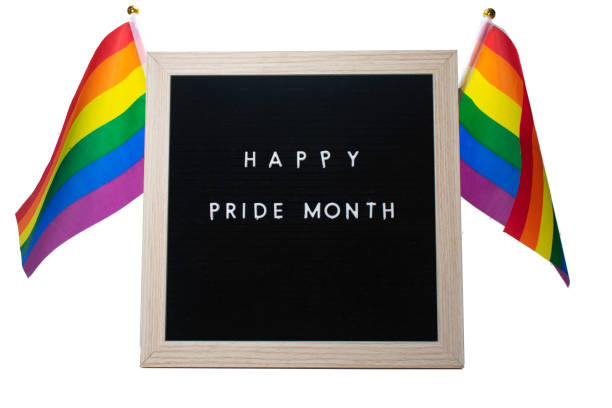 istock A Sign That Says Happy Pride Month With Pride Flags Behind It 1257453494