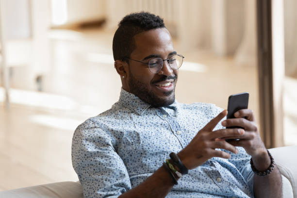 istock Smiling biracial man relax on couch using smartphone 1257454175