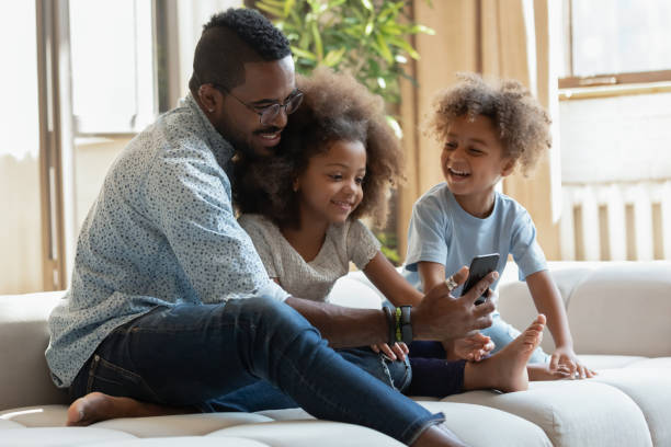 istock Happy biracial dad and kids using cellphone together 1257454188