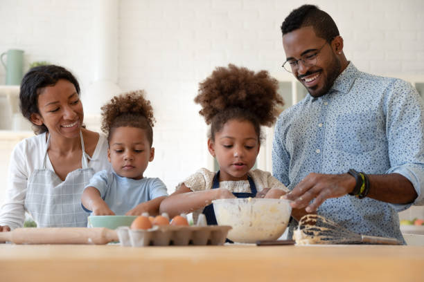 istock Loving parents teach little children baking in kitchen 1257454220