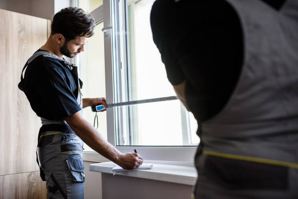 istock Our service is the best. Two professional workers in uniform using tape measure while measuring window and making notes for installing blinds indoors. Construction and maintenance concept 1257455559