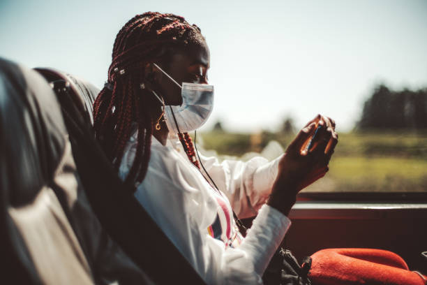 uma mulher negra mascarada em ônibus regular - teenager smart phone young women teenagers only - fotografias e filmes do acervo