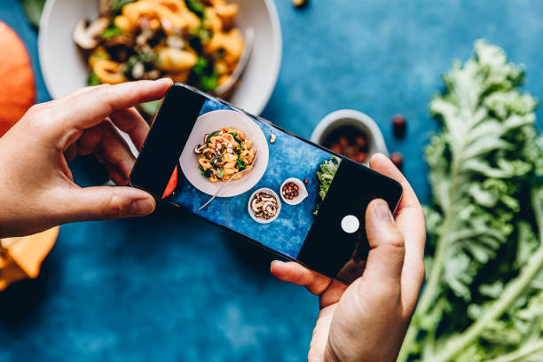 istock Woman photographing pumpkin pasta dish 1257464381
