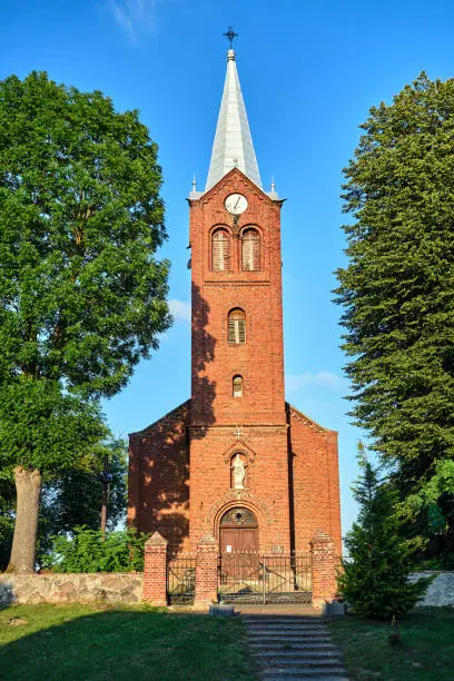 The tower of the historic, neo-Gothic red brick church in the village of Sokola Dabrowa in Poland