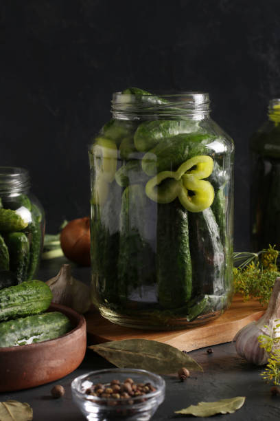 istock Marinated cucumbers with garlic, pepper and dill in a glass jars on dark background. 1257466794